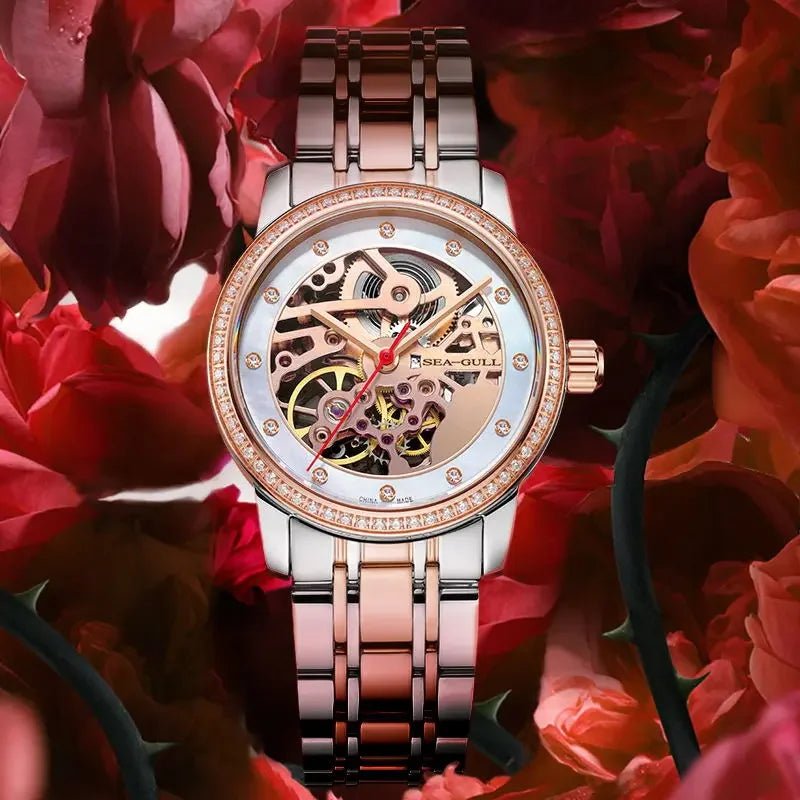 alt
Elegante orologio scheletrato con dettagli in oro rosa e lunetta con diamanti, sullo sfondo di rose rosse